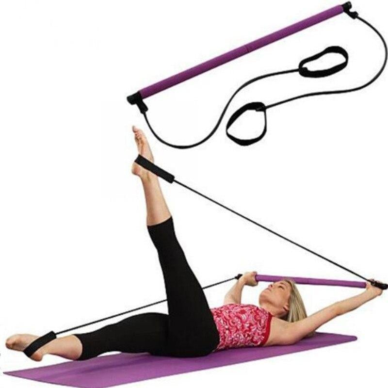 A person using a Pilates Squat Resistance Bar with Bands on a yoga mat, demonstrating a leg workout.