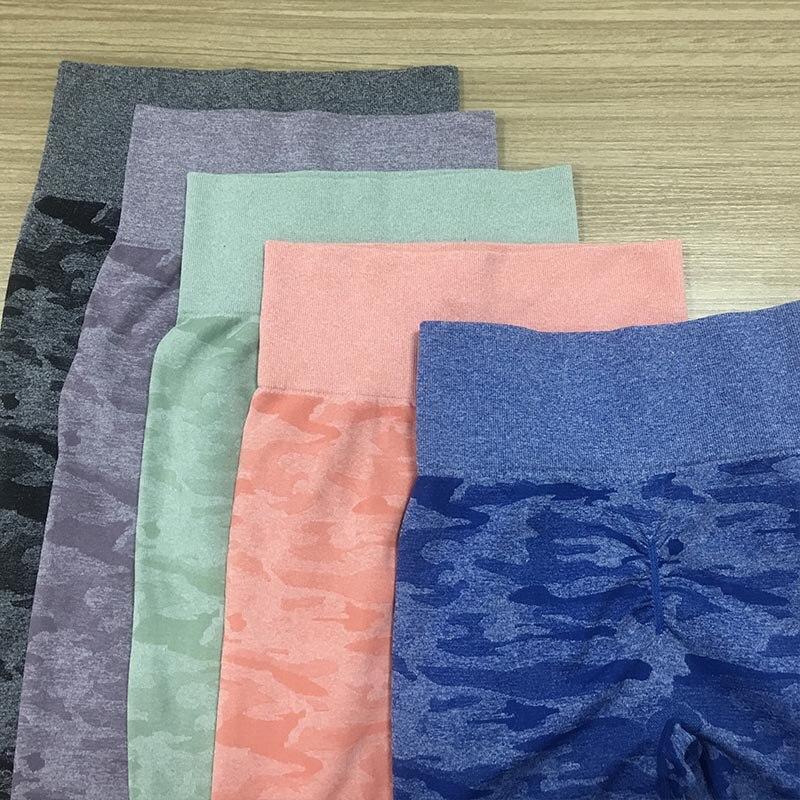 High waist fitness leggings in various colors and styles laid out on a wooden surface.
