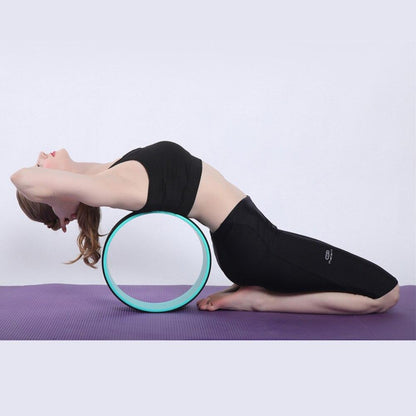 Woman using Yoga Pilates Circle Ring for deep stretching and improving flexibility during yoga practice.