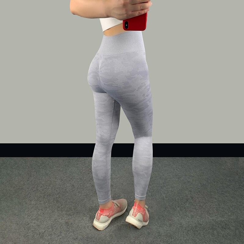 High waist fitness leggings in light gray showcasing a sleek and sculpted fit on a woman standing in athletic shoes.