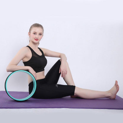 Yoga Pilates Circle Ring with a young woman performing stretches on a yoga mat, enhancing balance and flexibility.